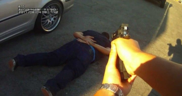 Police Officer Pointing Gun at Suspect on the Floor